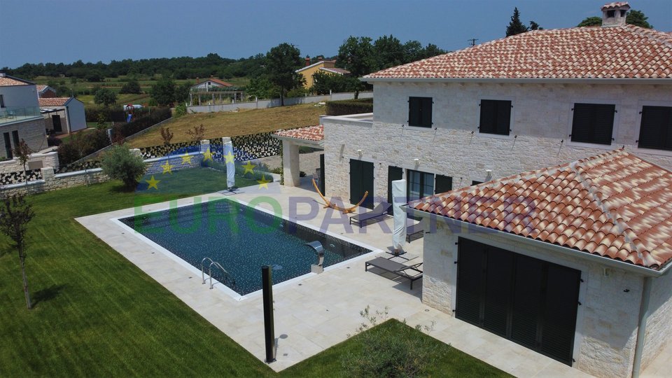 A modern villa with a swimming pool and a large garden