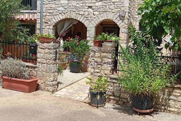 Kamena kuća u sredini niza , s otvorenim pogledom na zelena polja