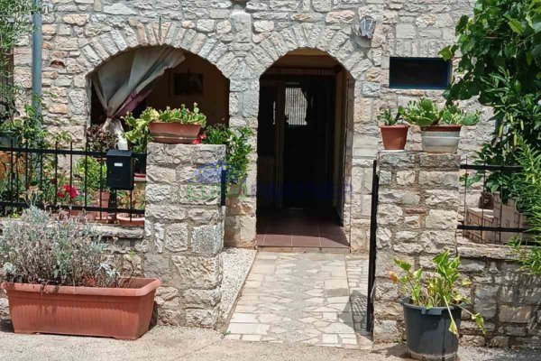 Kamena kuća u sredini niza , s otvorenim pogledom na zelena polja